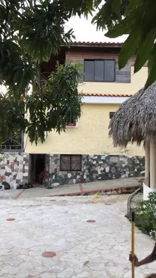 a house with a stone courtyard in front of it at VILLA CAMPESTRE EN LOMAS LINDA in Villa Altagracia