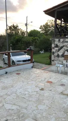 a white car parked next to a stone patio at VILLA CAMPESTRE EN LOMAS LINDA in Villa Altagracia