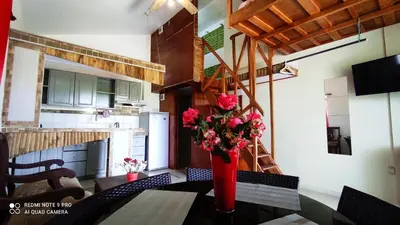 a red vase with flowers on a table in a kitchen at Private Study Punta Cana in Punta Cana