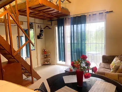 a living room with a table with flowers on it at Private Study Punta Cana in Punta Cana