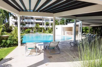 a patio with chairs and a swimming pool at Oasis Apartment C4 inside ALIGIO Residence Hotel in Las Terrenas