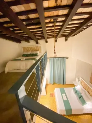 a room with two beds and a table in it at Mosquito Boutique Hotel Zona Colonial in Santo Domingo