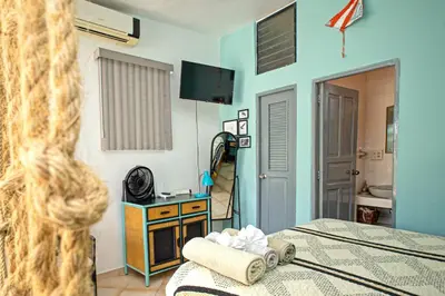 a bedroom with a bed and a television and a room at Studio Apartment Center of Sosua Remote Worker Space Fast WiFi in Sosúa