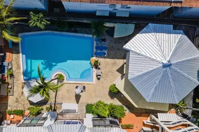 an overhead view of a swimming pool with an umbrella at Studio Apartment Center of Sosua Remote Worker Space Fast WiFi in Sosúa
