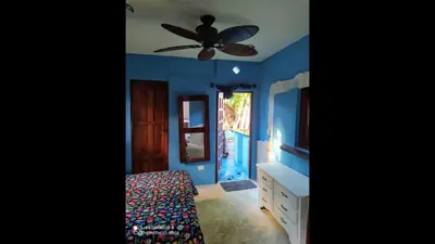 a bedroom with blue walls and a ceiling fan at Method Living Tropical Edition 50024 in Cabarete