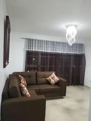 a living room with a brown couch in front of a window at Cerro Altos jardin 809-488-8618 in Santiago de los Caballeros