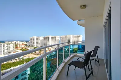 two chairs on a balcony with a view of the city at Sunset View 2BR Apartamento Juan Dolio Las Velas in Juan Dolio