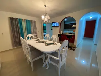a dining room with a white table and white chairs at 6A Cozy Apt in Santiago Center - Great Stay in Santiago de los Caballeros