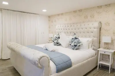 a bedroom with a large white bed with a large headboard at Santo Domingo Luxury Apartment with 8 Bedrooms in Santo Domingo