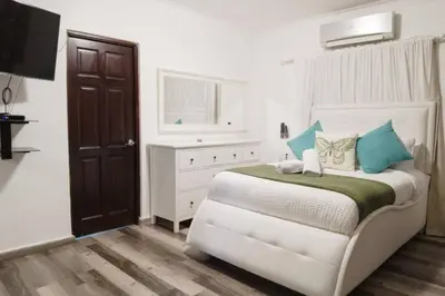 a bedroom with a white bed with blue pillows at Santo Domingo Luxury Apartment with 8 Bedrooms in Santo Domingo