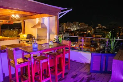 a wooden table and chairs on a balcony at night at Santo Domingo Luxury Apartment with 8 Bedrooms in Santo Domingo