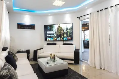 a living room with white couches and a tv at Santo Domingo Luxury Apartment with 8 Bedrooms in Santo Domingo