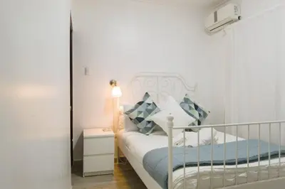 a small bedroom with a white bed and a lamp at Santo Domingo Luxury Apartment with 8 Bedrooms in Santo Domingo