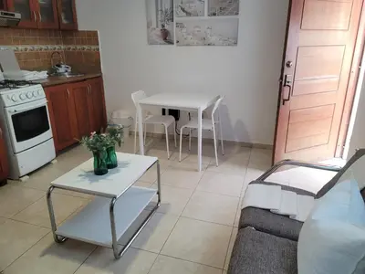 a living room with a table and a kitchen at small apartment in Santo Domingo