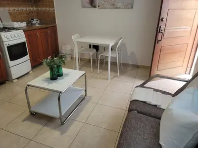 a living room with a table and a kitchen at small apartment in Santo Domingo
