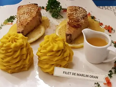 a plate of food with fish and potatoes and a cup of tea at Las Puertas del Paraíso in Río San Juan