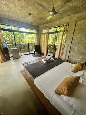a bedroom with a large bed with a large window at Taino Beach Lofts in El Valle