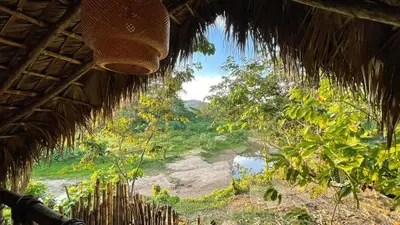 a view of a river from a straw hut at Bungalows India, El Valle, Samana in Santa Bárbara de Samaná