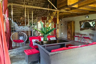 a living room with red chairs and a table at Bungalows India, El Valle, Samana in Santa Bárbara de Samaná