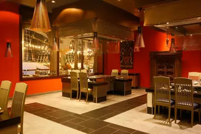 a restaurant with red walls and a table and chairs at JOIA Bavaro by Iberostar - Adults Only All Inclusive Resort in Punta Cana