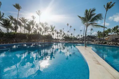 a large swimming pool with palm trees in the background at Iberostar Waves Punta Cana - All Inclusive in Punta Cana