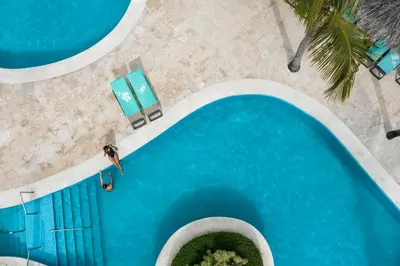 an overhead view of a swimming pool with a surfer in the water at Iberostar Waves Dominicana - All Inclusive in Punta Cana