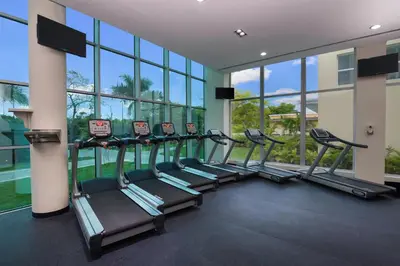 a row of treadmills in a gym with windows at Iberostar Waves Dominicana - All Inclusive in Punta Cana
