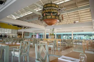 a dining room with tables and chairs and a chandelier at Iberostar Waves Dominicana - All Inclusive in Punta Cana