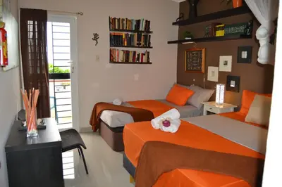 a bedroom with two beds and a book shelf at ECOVILLA CORAL GARDEN in Baoruco