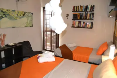 a room with two beds and a book shelf at ECOVILLA CORAL GARDEN in Baoruco