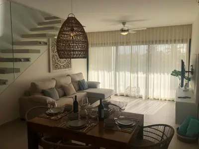 a living room with a table and a couch at Hermoso Penthouse a solo pasos de la Playa in Punta Cana