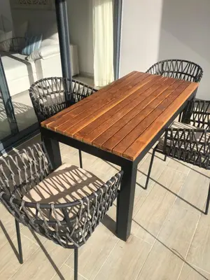 a wooden table and two chairs and a wooden table and chairs at Hermoso Penthouse a solo pasos de la Playa in Punta Cana