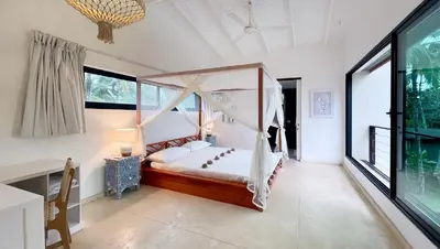 a bedroom with a bed in a room with large windows at Villa Isha - modernist hideaway at Cap Bonita in Las Terrenas