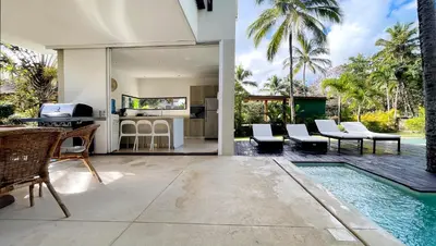 an open living room with a pool and a house at Villa Isha - modernist hideaway at Cap Bonita in Las Terrenas