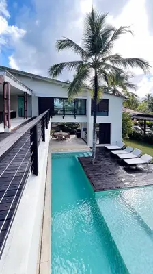a house with a swimming pool and a palm tree at Villa Isha - modernist hideaway at Cap Bonita in Las Terrenas