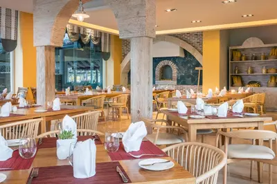 an empty restaurant with wooden tables and chairs at Iberostar Selection Bavaro Suites - All Inclusive in Punta Cana