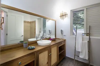 a bathroom with a sink and a large mirror at Punta Rucia Lodge Hotel Boutique & Spa in Punta Rucia