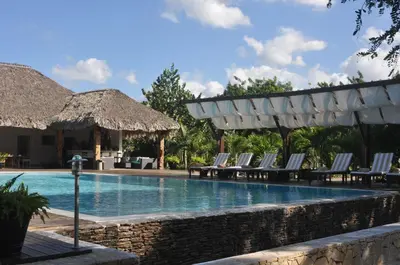 a pool at a resort with chairs and a pavilion at Punta Rucia Lodge Hotel Boutique & Spa in Punta Rucia