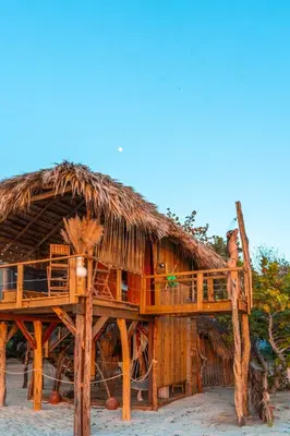 a hut with a thatched roof on the beach at Punta Rucia Lodge Hotel Boutique & Spa in Punta Rucia
