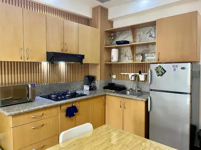 a kitchen with wooden cabinets and a white refrigerator at Estancia Casa Real Frente a la Zona Colonial in Calero