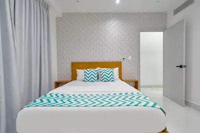 a bedroom with a bed with a blue and white pillow at Monaco Residences Piantini in Santo Domingo