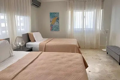 a hotel room with two beds and a couch at Beach Residence | Escapada Penthouse Vista Mar in Punta Cana