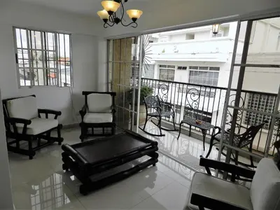 a room with a balcony with chairs and a table at Hotel La Colonia in Santo Domingo