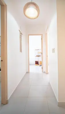 a hallway with white walls and a ceiling with a light fixture at Villa Pauline in Bayahibe