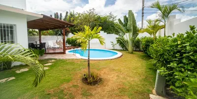 a backyard with a pool and a palm tree at Villa Pauline in Bayahibe