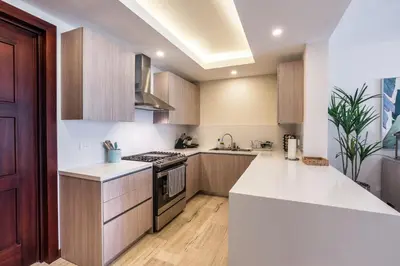 a kitchen with white counters and a stove top oven at 3BR apartment with balcony in Portillo - Terrenas in Abra Grande
