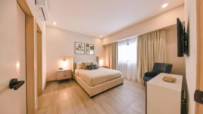 a hotel room with a bed and a desk at Fully Serviced Apartment at Regatta Living II - 304 in Santo Domingo