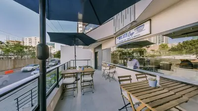 an outdoor patio with tables and chairs and umbrellas at Fully Serviced Apartment at Regatta Living II - 304 in Santo Domingo