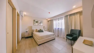 a bedroom with a bed and a desk and a chair at Fully Serviced Apartment at Regatta Living II - 905 in Santo Domingo