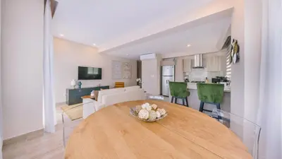 a dining room and living room with a wooden table at Fully Serviced Apartment at Regatta Living II - 907 in Santo Domingo